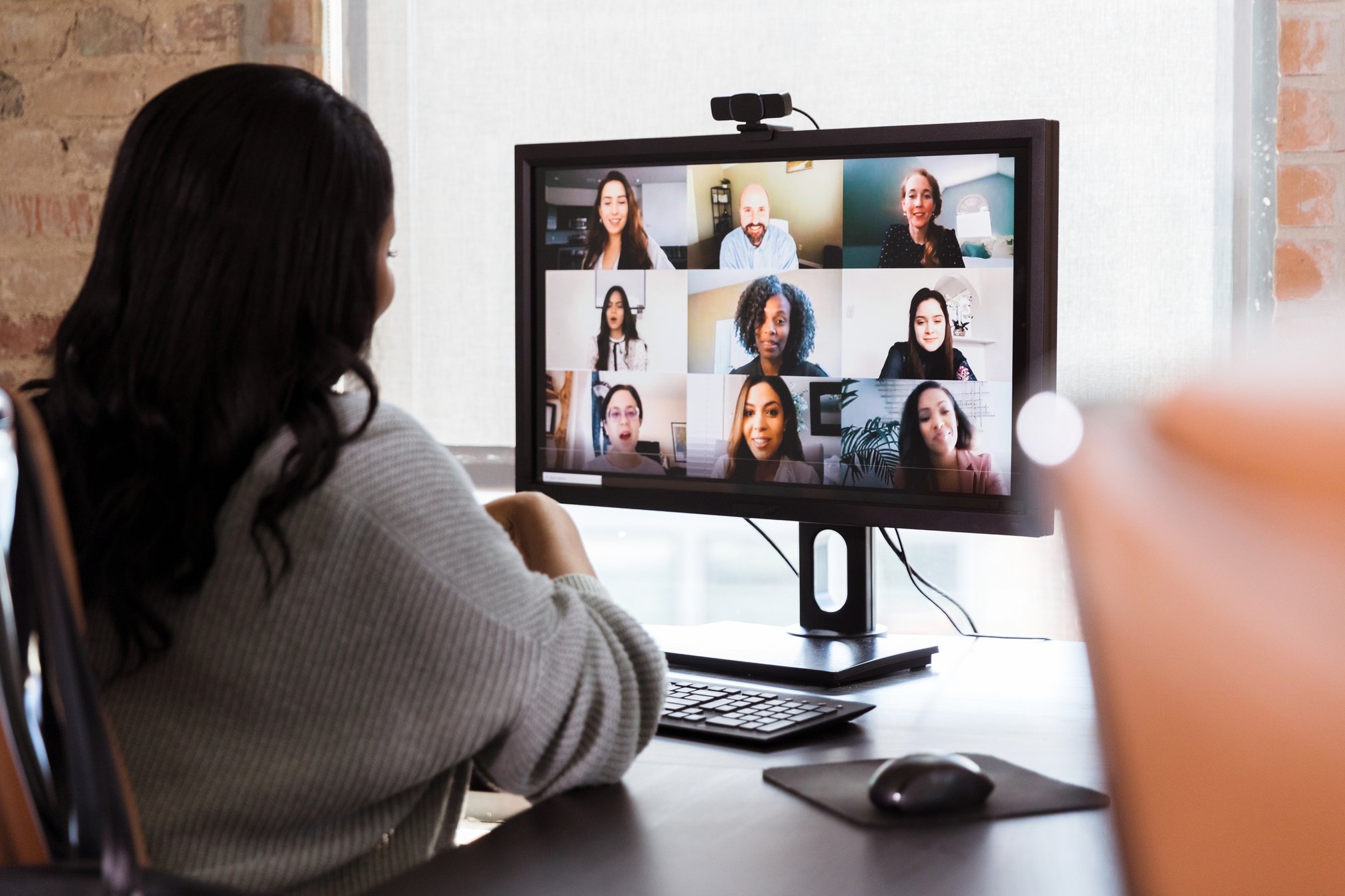 Businesswoman meets with colleagues in the virtual meeting in the background