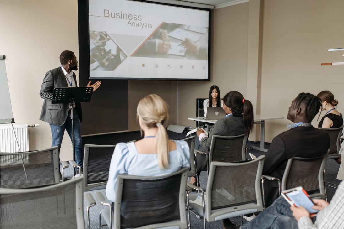 Men in black blazer, giving a presentation